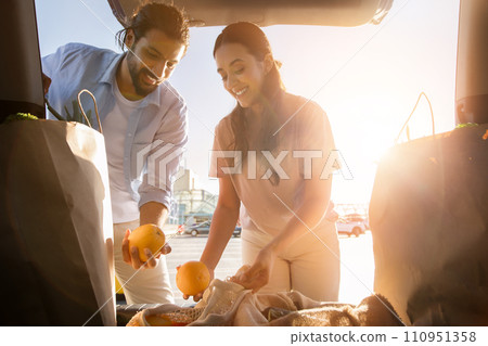 Arab couple admiring groceries at sunset 110951358