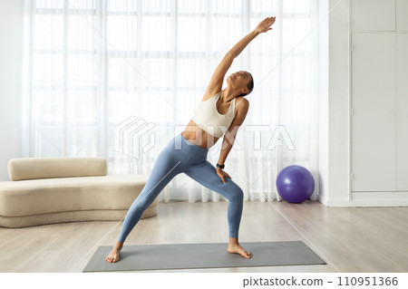 Happy pretty slim young latina lady athlete in sportswear doing stretching hands exercises Happy pretty slim young latina lady athlete in sportswear doing stretching hands exercises 110951366
