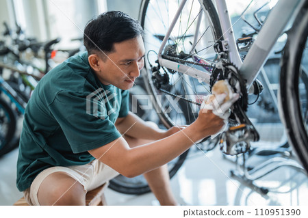 young man washes new bicycle gear with soap at a bicycle shop 110951390