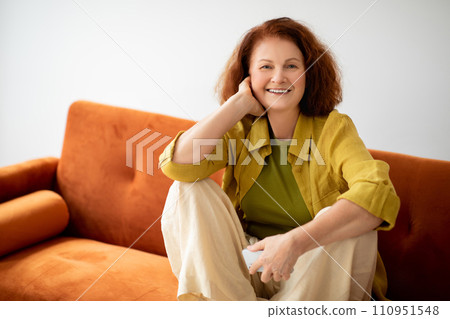 Senior Woman With Smartphone In Hand Relaxing On Comfortable Couch At Home Senior Woman With Smartphone In Hand Relaxing On Comfortable Couch At Home 110951548