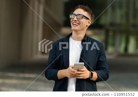 Smiling shocked millennial caucasian guy in casual, glasses with open mouth use phone 110951552