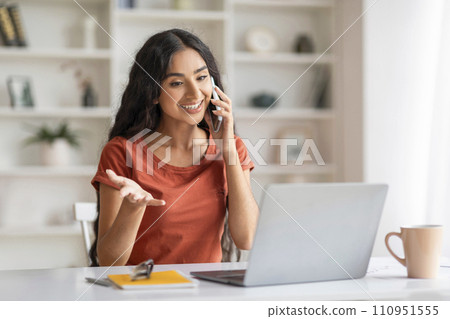Cheerful young indian woman entrepreneur working from home 110951555
