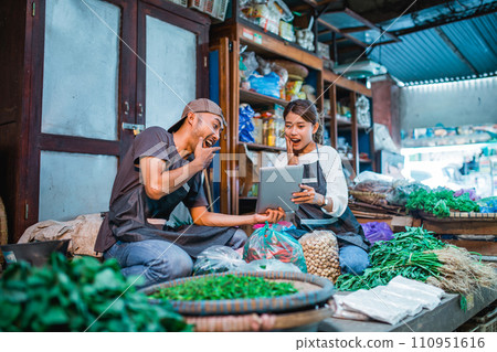 vegetable sellers looked surprised while holding tablet 110951616