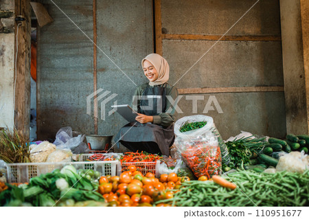 asian vegetable seller looking tablet checking supply asian vegetable seller looking tablet checking supply 110951677