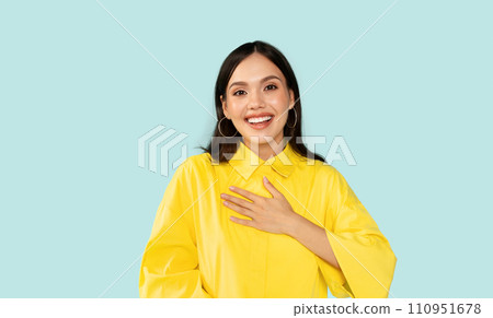 Happy young woman touching her chest and smiling Happy young woman touching her chest and smiling 110951678