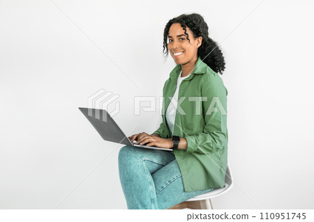 African woman engages in freelance work on laptop, white studio African woman engages in freelance work on laptop, white studio 110951745