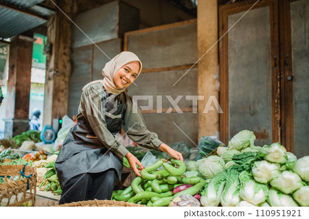 asian hijab green grocery seller arranging vegetables 110951921