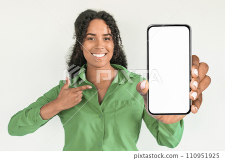 black lady points at large phone display on white background 110951925