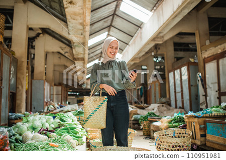 female customer looking at phone farmer market 110951981