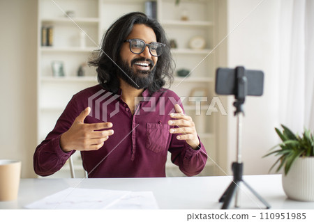 Young Indian Male Blogger Recording Video At Home With Smartphone On Tripod Young Indian Male Blogger Recording Video At Home With Smartphone On Tripod 110951985