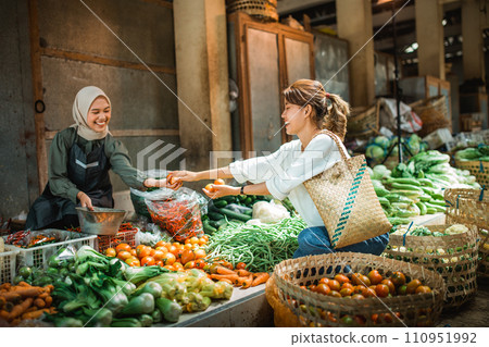 happy seller helping customer choosing greengroceries 110951992