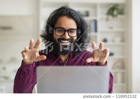 Distant Communication. Happy Eastern Man In Headset Talking At Laptop Camera 110952132