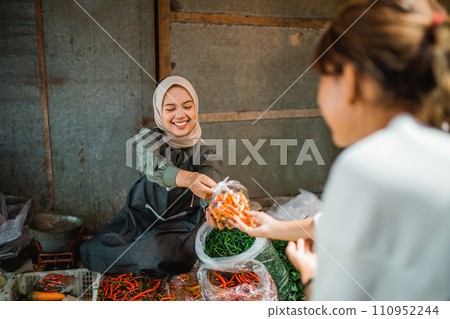 asian seller passing wrapped vegetable customer 110952244