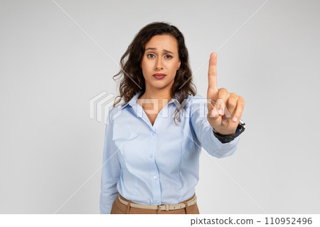 Serious confident millennial caucasian business lady, teacher in formal wear point finger up 110952496