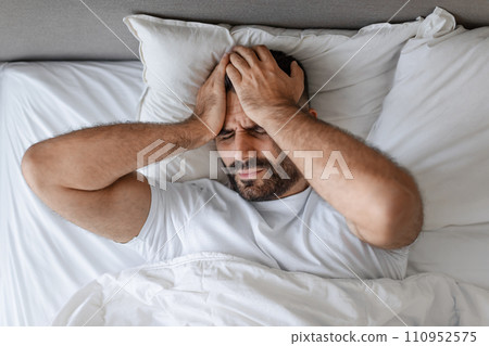 man touching head with pained expression suffering from headache indoor 110952575