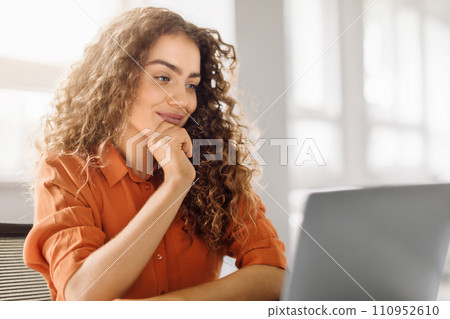 Thoughtful young businesswoman at laptop in sunny office 110952610