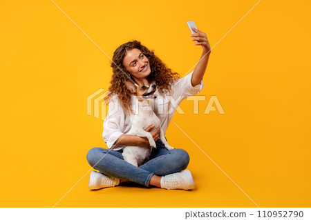 Woman and dog take selfie on yellow background Woman and dog take selfie on yellow background 110952790