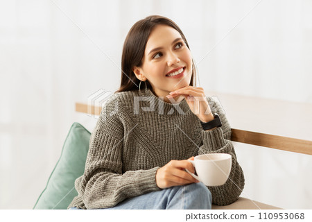 Lady holding cup, enjoying hot drink at home Lady holding cup, enjoying hot drink at home 110953068