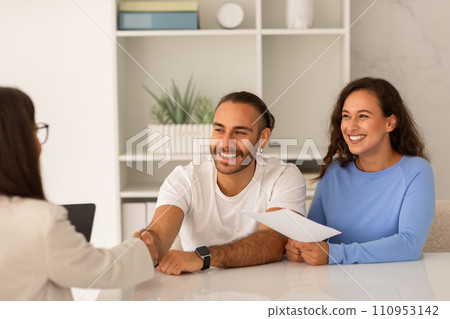 Young couple visiting doctor, shaking hand, happy with results 110953142