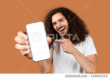 Smiling guy holding empty smartphone screen against beige backdrop Smiling guy holding empty smartphone screen against beige backdrop 110953153