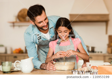 Father and daughter mixing batter together 110953199