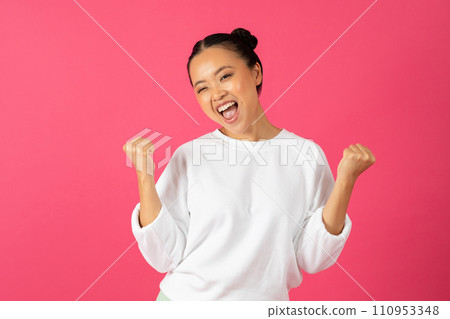 Portrait Of Joyful Asian Woman Celebrating Success While Standing On Pink Background Portrait Of Joyful Asian Woman Celebrating Success While Standing On Pink Background 110953348