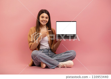 Great Website. Cheerful teen girl pointing at laptop with blank screen 110953440