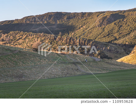 The breathtaking scenic landscape of Holyrood park with Salisbury Crags rugged hills and sky background. 110953628