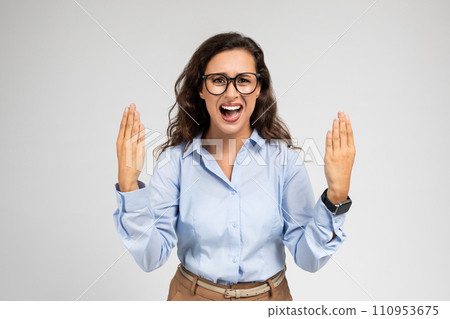Angry upset young european lady in formal wear raises hands, screams, freaking out Angry upset young european lady in formal wear raises hands, screams, freaking out 110953675