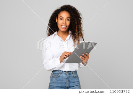 African American lady using her tablet computer for business, studio 110953752