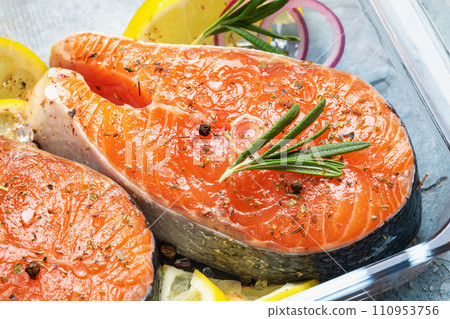 Raw red fish steak with various spices in a glass pallet, close-up 110953756