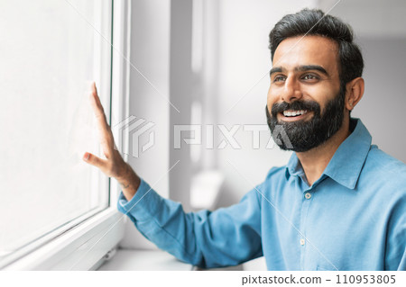 Happy indian businessman smiling by the window Happy indian businessman smiling by the window 110953805