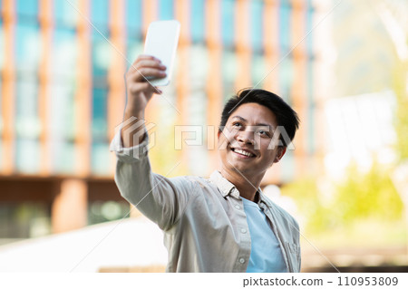 Handsome young asian man entrepreneur taking selfie on the street 110953809