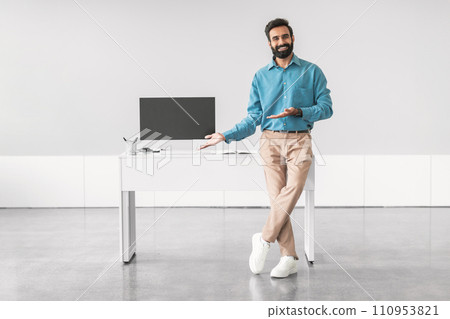 Happy indian businessman presenting blank computer monitor Happy indian businessman presenting blank computer monitor 110953821