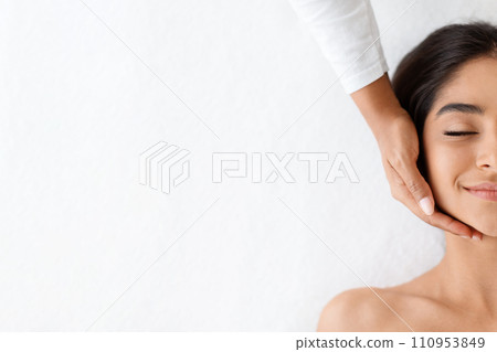 Half face of indian woman enjoying face massage in spa Half face of indian woman enjoying face massage in spa 110953849