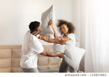 Joyful African Couple Having Pillow Fight For Fun In Bedroom 110953863