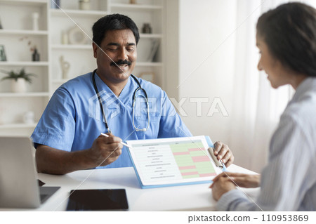 Indian Doctor Man Discussing Medical Test Results With Young Female Patient In Clinic 110953869