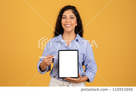 Glad latin millennial brunette woman show tablet with empty screen and pen Glad latin millennial brunette woman show tablet with empty screen and pen 110953898