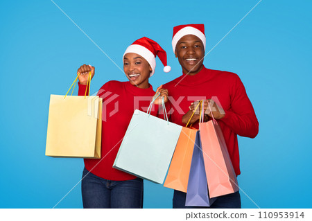 Happy Black Spouses Advertising Holiday Shopping Holding Bags, Blue Background 110953914
