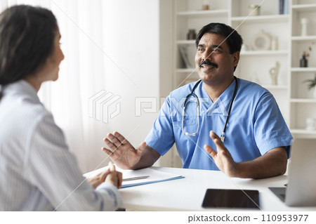 Indian Male Doctor In Blue Uniform Consulting Young Female Patient In Clinic 110953977