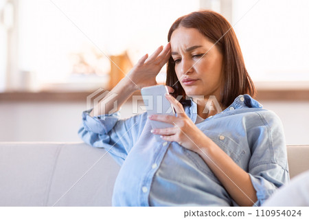 Discontented Pregnant Lady Websurfing On Cell Phone Sitting At Home Discontented Pregnant Lady Websurfing On Cell Phone Sitting At Home 110954024