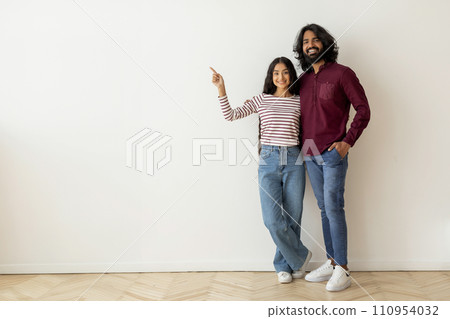 Happy young indian couple buying new house. pointing copy space 110954032