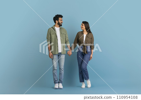 Romantic millennial indian couple posing on blue studio background 110954108