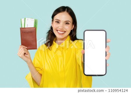 Positive woman tourist holding passport with travel tickets and smartphone Positive woman tourist holding passport with travel tickets and smartphone 110954124