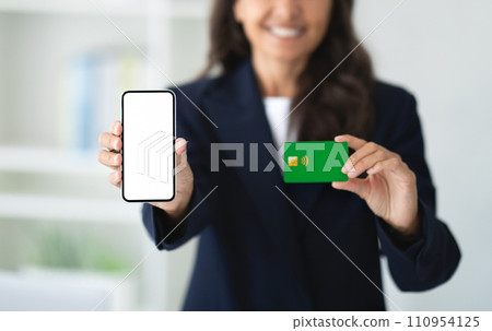 Cropped of woman showing phone and credit card 110954125