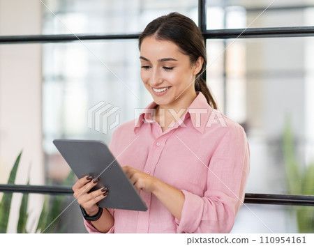 Glad young arab lady manager typing on tablet, chatting, enjoy work, business Glad young arab lady manager typing on tablet, chatting, enjoy work, business 110954161
