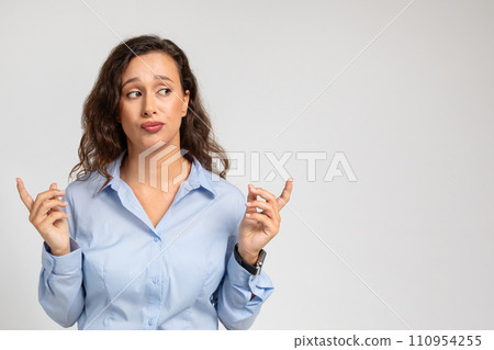 Confused doubt millennial european lady in formal wear hold with fingers copy space, show size 110954255