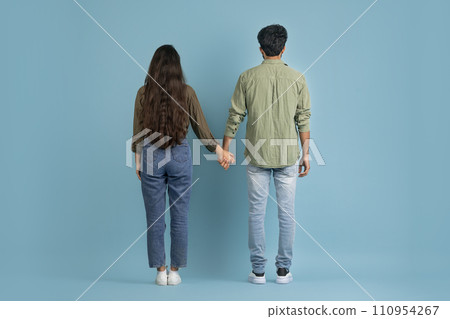 Back view of millennial couple posing on blue background 110954267