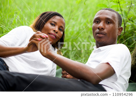 Portrait of couple lying on the green grass 110954296