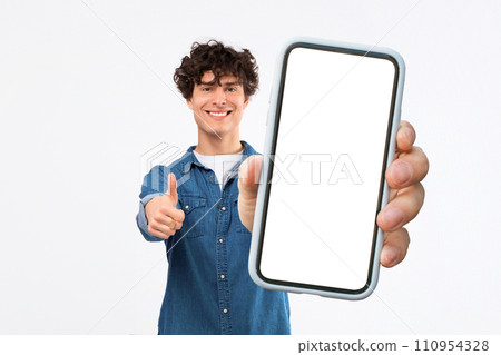 Man Poses Holding Huge Smartphone Advertising Empty App Screen, Studio Man Poses Holding Huge Smartphone Advertising Empty App Screen, Studio 110954328